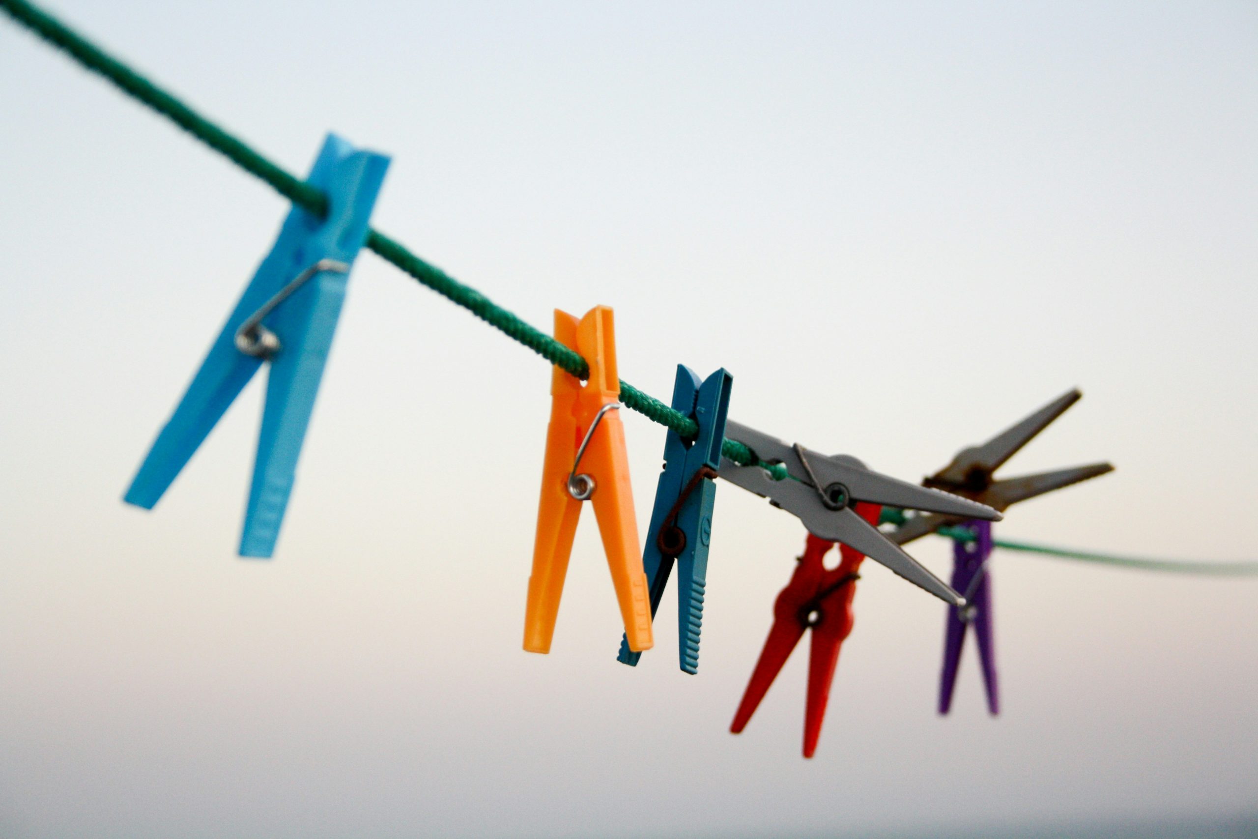 Image of washing line with mutli coloured pegs hanging off it.